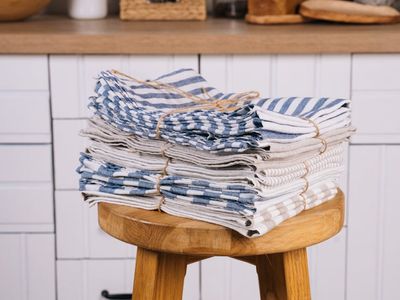 A stack of neatly folded towels and a small plant.